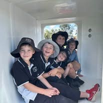 students smiling in the back of a police van