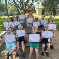 students and their easter hat parade certificates