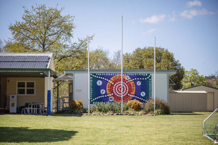 an Aboriginal painting in front of a school