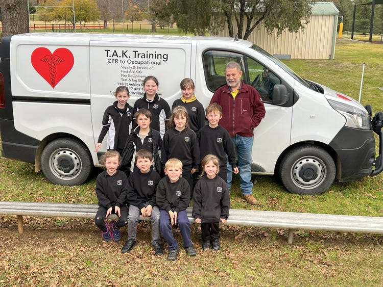 children together Infront of the first aid training van